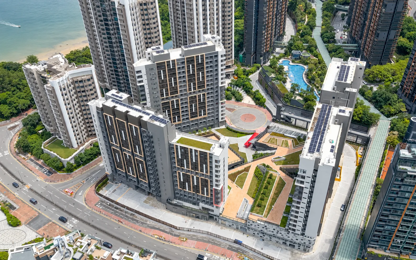 Aerial view of student hostel towers by the sea at Whitehead, Ma On Shan, with rooftop solar panels and landscaped courtyards
