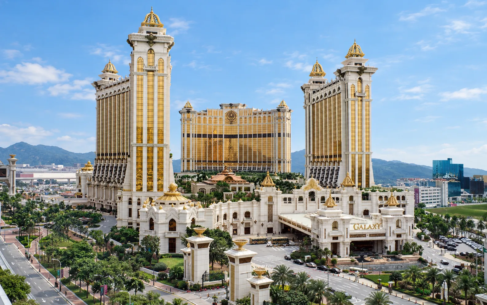 Resort towers with gold facades and domed crowns, with a GALAXY sign above the entrance plaza