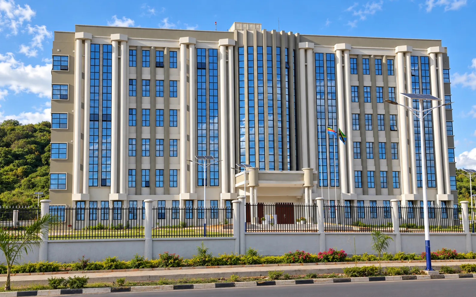 Nine-storey government office building in Tanzania with tall glazed bays, columns and a fenced forecourt