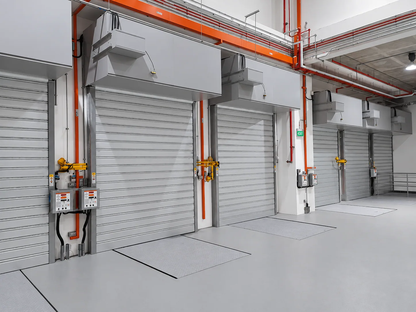Row of fire roller shutters with control boxes along a building corridor