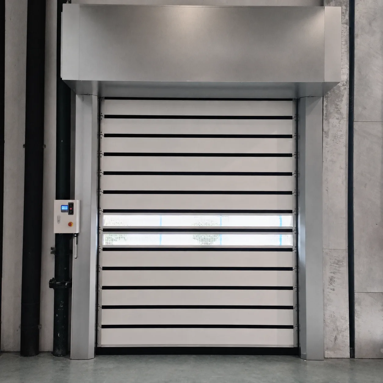 White high speed spiral door with aluminum slats, two clear vision slats and a spiral hood, with its control box beside the opening