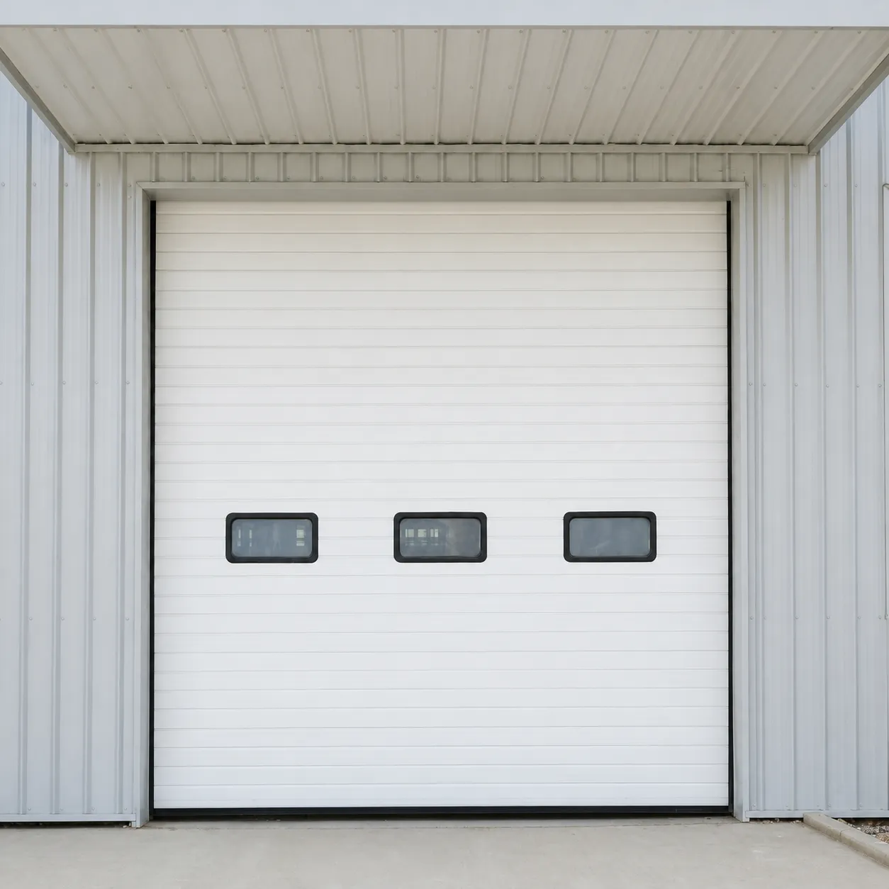 White sectional door with three windows under a canopy