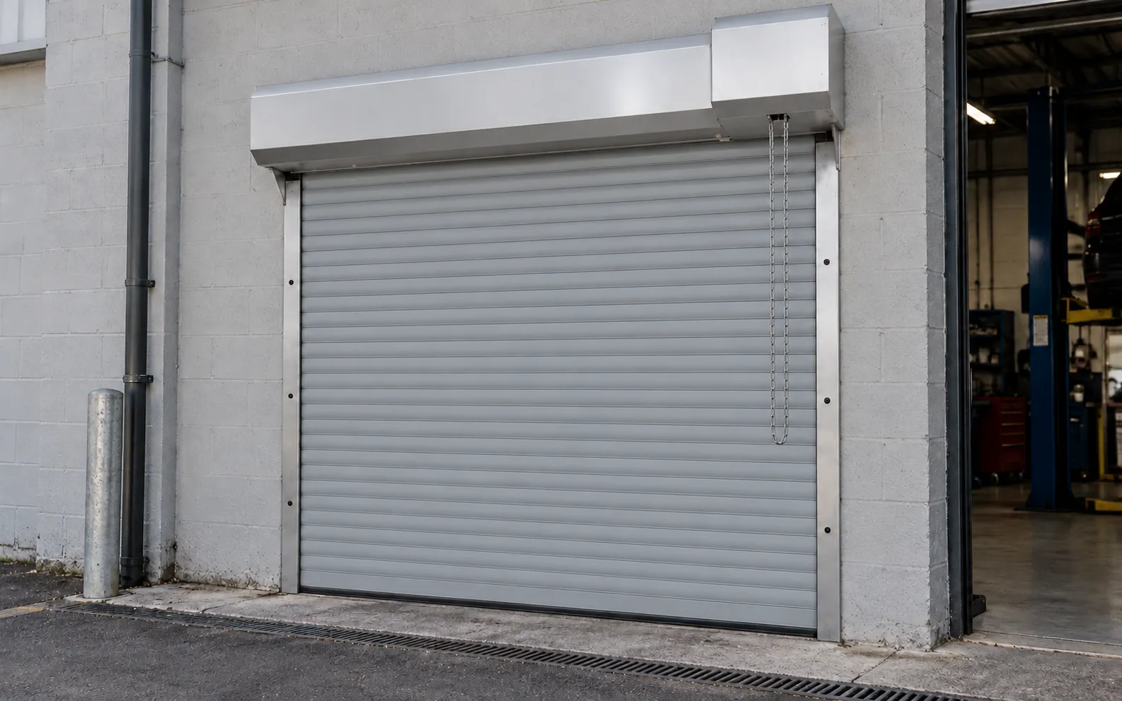 Light grey prepainted steel roller shutter in a maintenance workshop (rendering)