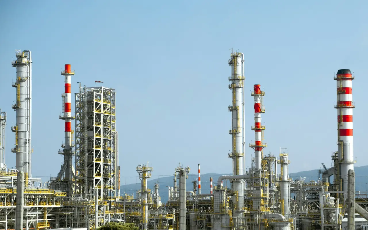 Oil refinery columns and stacks against a blue sky