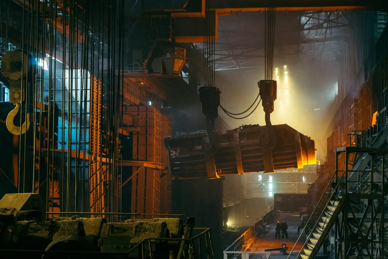 Steel mill interior with a crane lifting a ladle