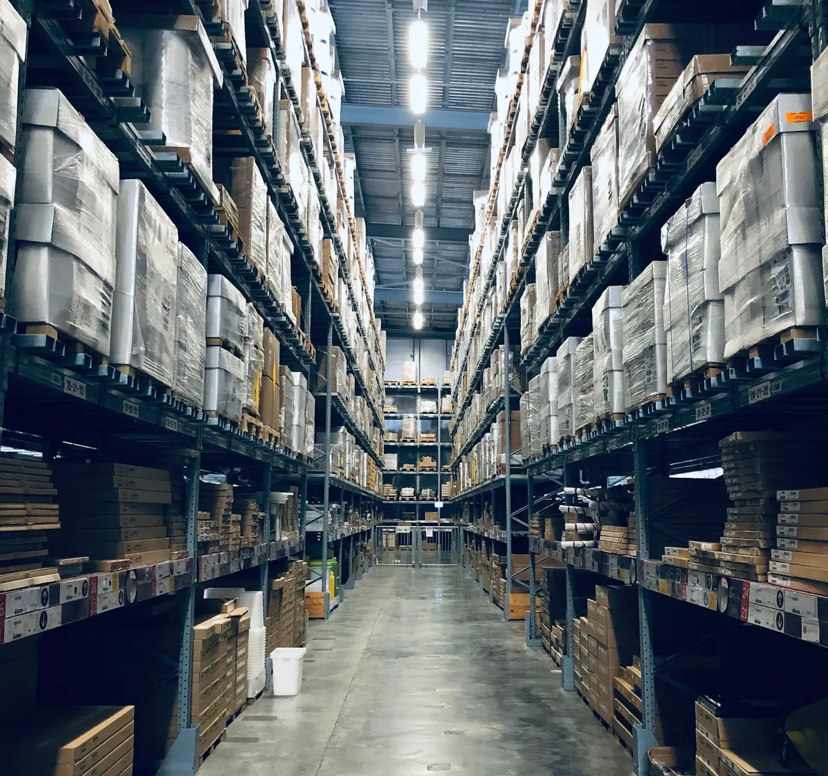 Warehouse aisle between tall racks of palletised goods